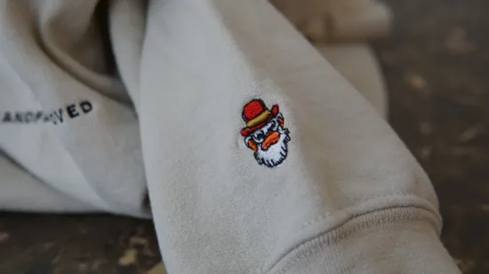 Logo on left sleeve of sand sweater